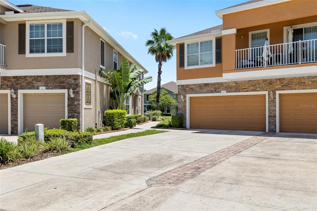 7001 Interbay Boulevard, Unit 303 Tampa, FL 33616 - Photo 3 of 37 a front view of a house with a yard and garage