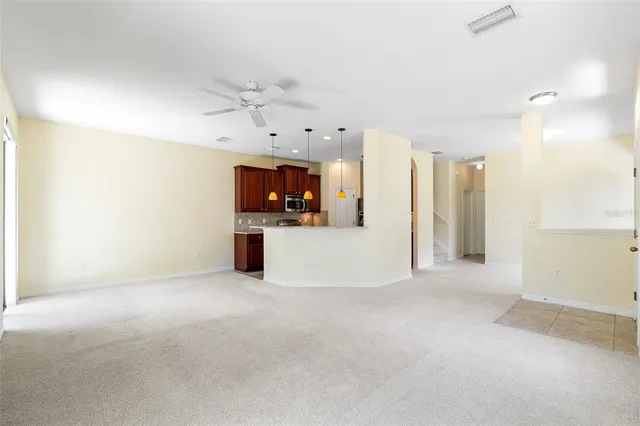an empty room with a kitchen and a fireplace