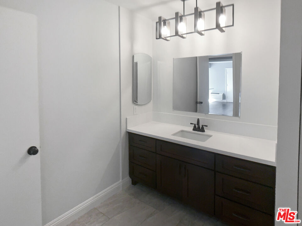 99 Streamwood Irvine, CA 92620 - Photo 11 of 12 a bathroom with a double vanity sink a mirror and shower