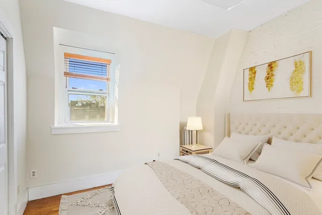 a bedroom with a bed and a painting on the wall