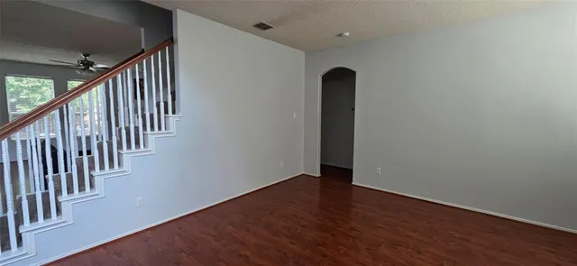 an empty room with a window and a fan