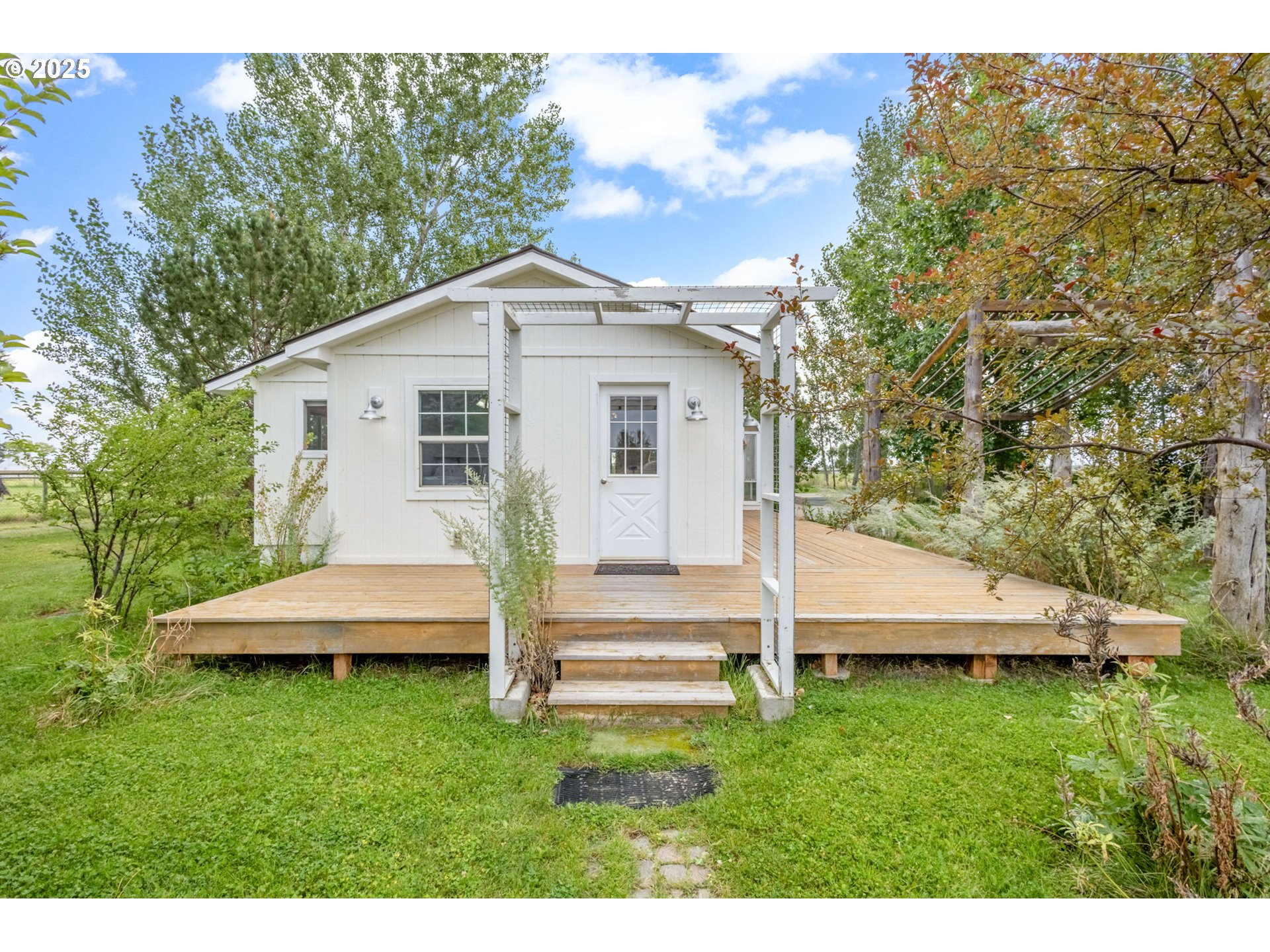 26315 Walker Road Bend, OR 97701 - Photo 21 of 45 a view of a white house with a big yard plants and large trees