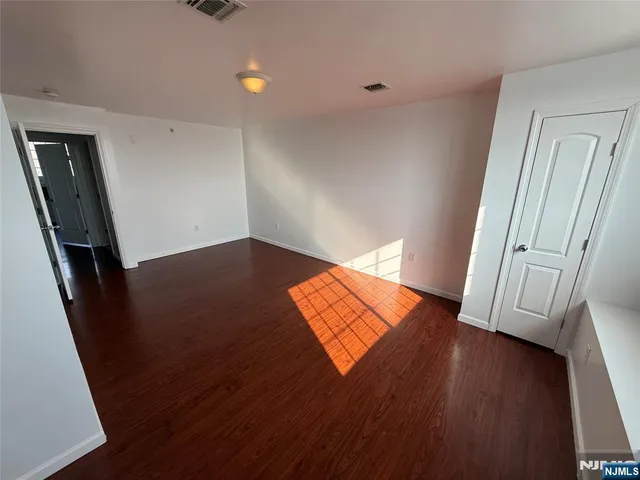 an empty room with wooden floor and a window