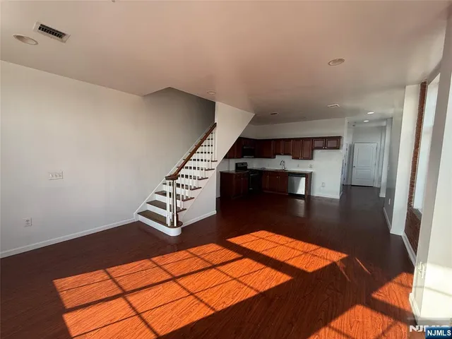 a view of a room with wooden floor and furniture