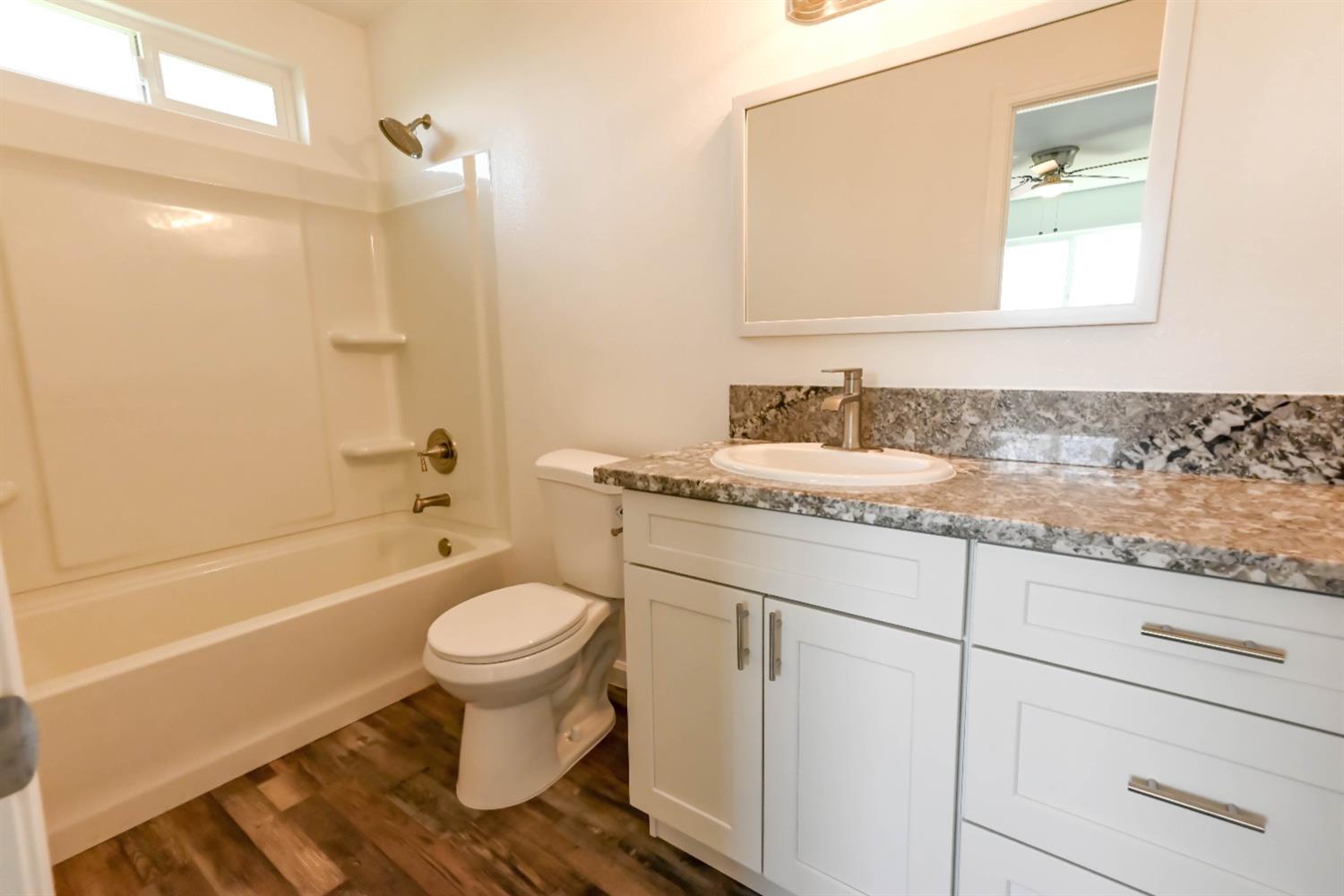 18071 Daley Road Madera, CA 93638 - Photo 13 of 25 a bathroom with a granite countertop toilet sink and mirror