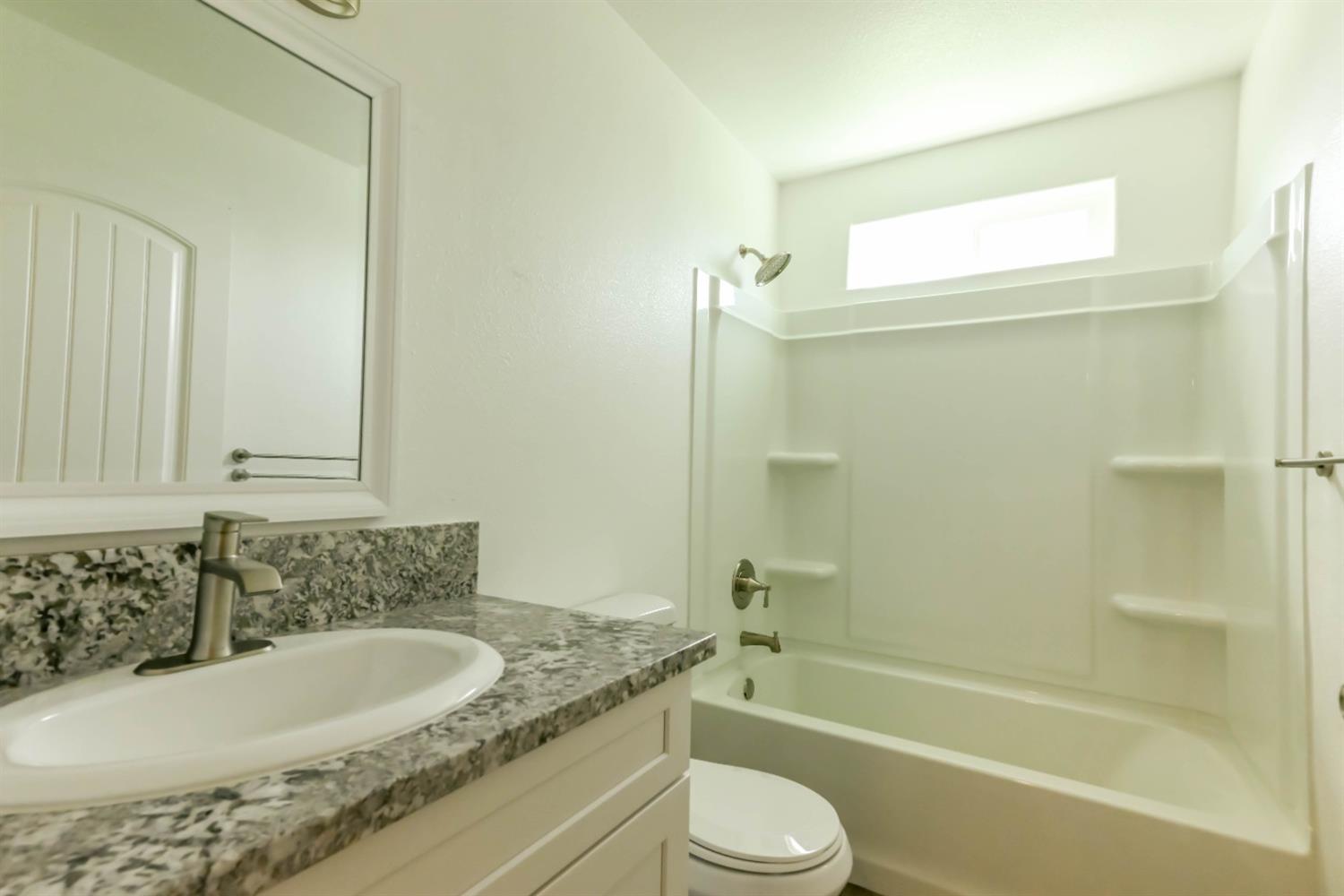 18071 Daley Road Madera, CA 93638 - Photo 17 of 25 a bathroom with a granite countertop sink a toilet and bathtub