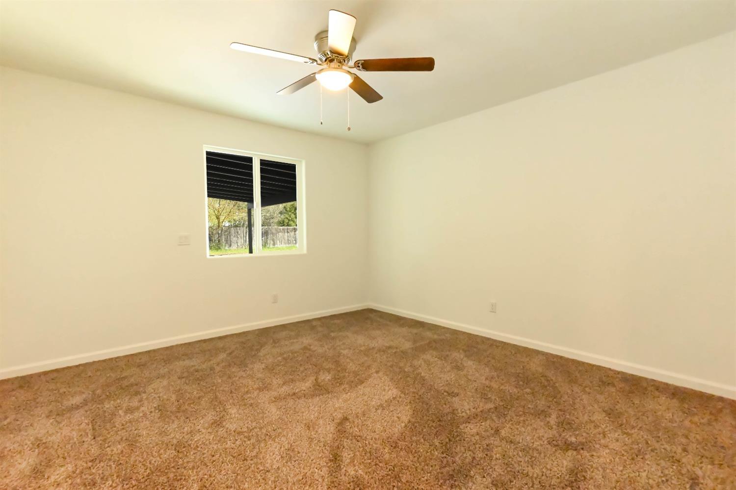 18071 Daley Road Madera, CA 93638 - Photo 19 of 25 an empty room with a window and a ceiling fan