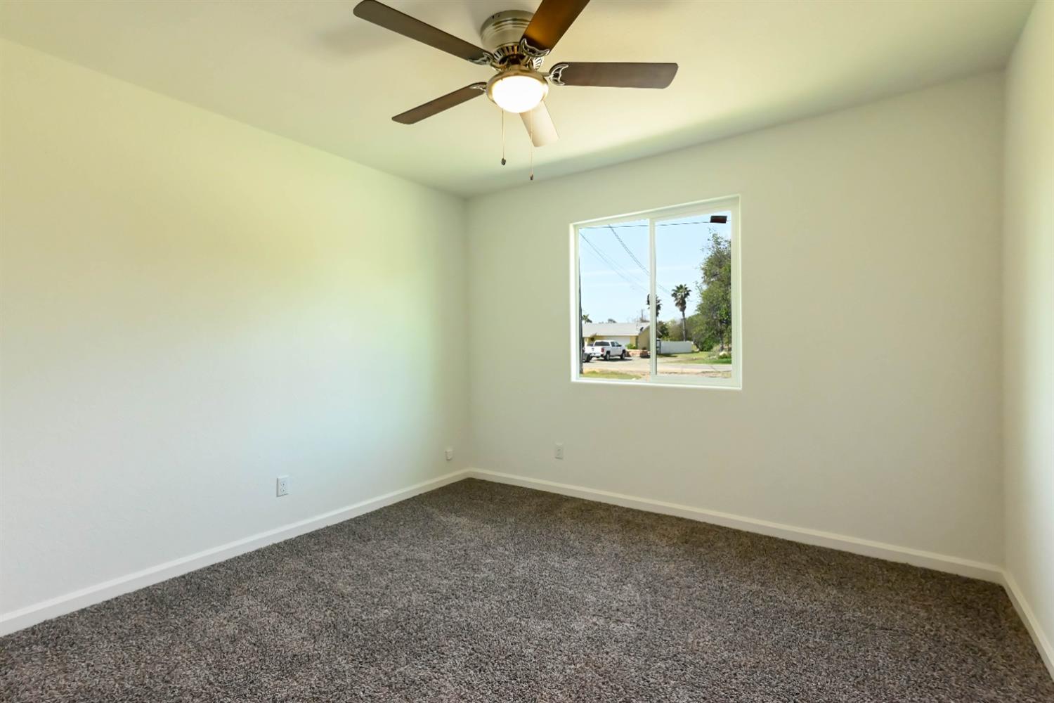 18071 Daley Road Madera, CA 93638 - Photo 2 of 25 an empty room with a window and a ceiling fan