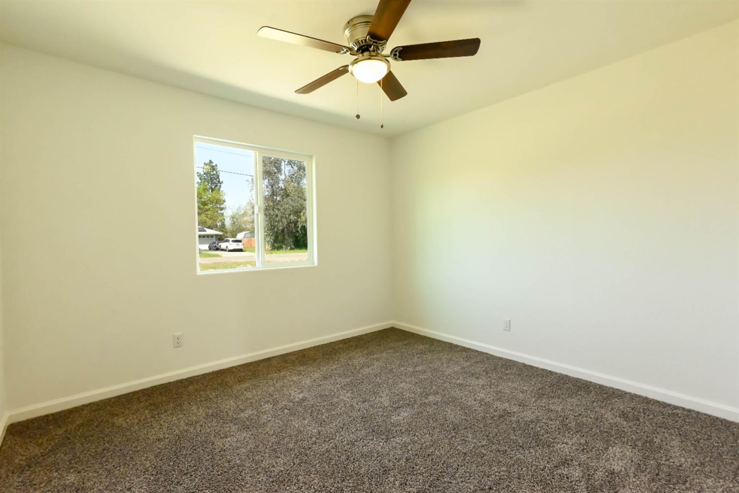 18071 Daley Road Madera, CA 93638 - Photo 3 of 25 an empty room with a window and a fan