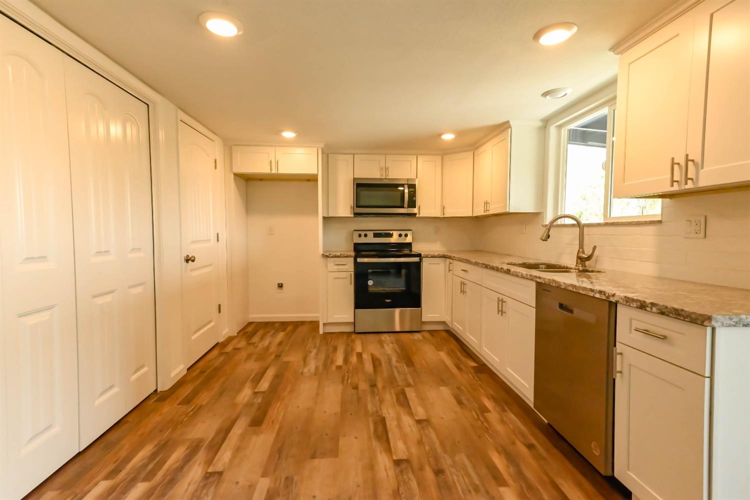 18071 Daley Road Madera, CA 93638 - Photo 4 of 25 a large kitchen with cabinets stainless steel appliances and a window