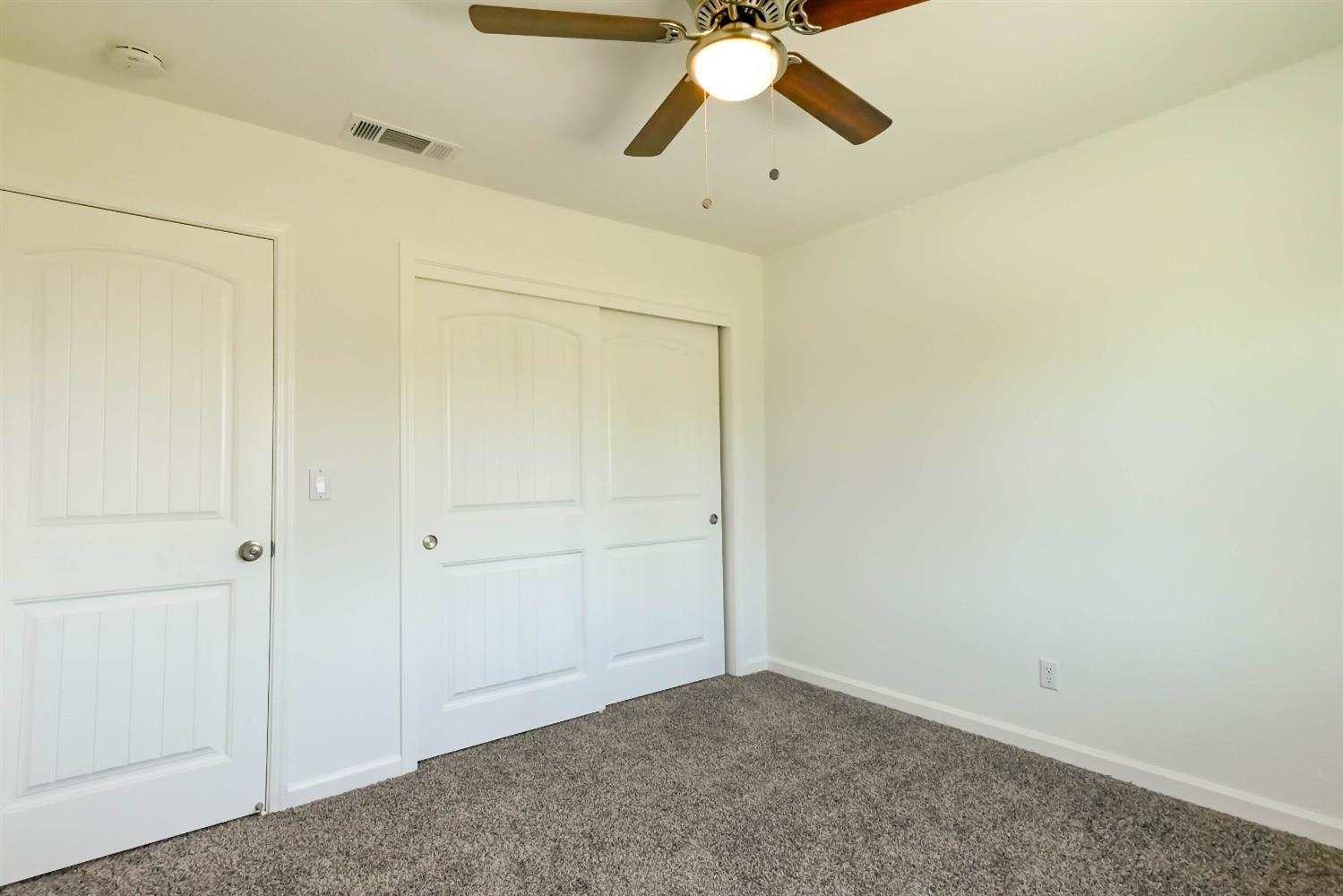 18071 Daley Road Madera, CA 93638 - Photo 10 of 25 an empty room with closet and chandelier fan