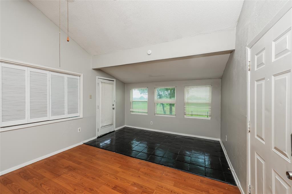 9696 Walnut Street, Unit 1216 Dallas, TX 75243 - Photo 14 of 19 Room featuring vaulted ceilings and a combination of wood-finish flooring and dark tile