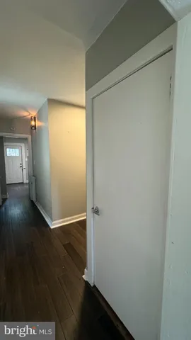 an empty room with wooden floor door and windows