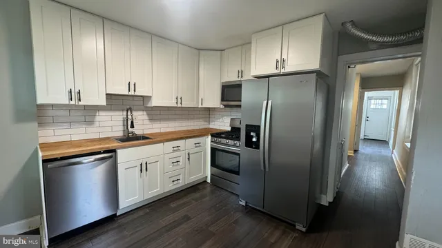 a kitchen with stainless steel appliances granite countertop a refrigerator and a sink