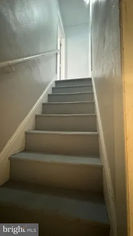 an empty room with wooden floor closet and fan