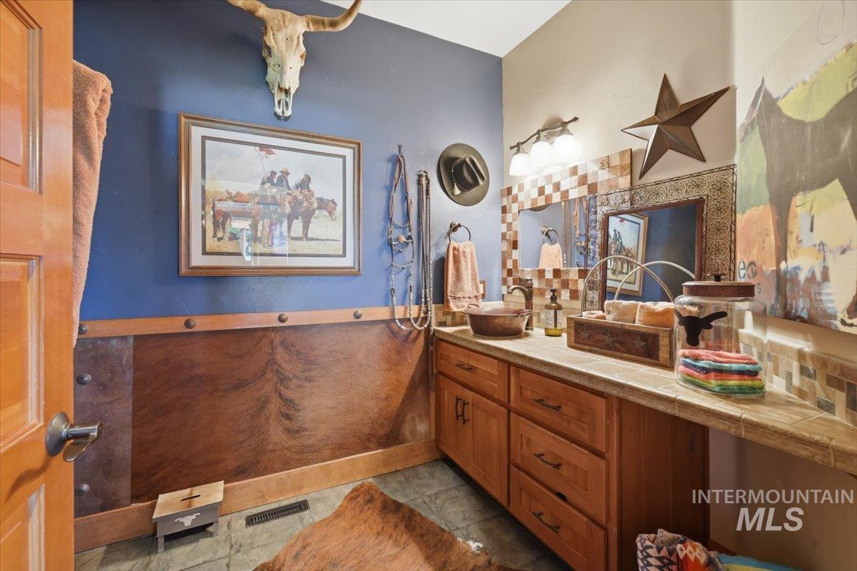 20337 Maggard Lane Caldwell, ID 83607 - Photo 24 of 50 This room is large and encompasses laundry, an area to put a desk and work, numerous hooks for coats, storage, and two double-door pantry areas with plentiful storage for food and kitchen essentials.