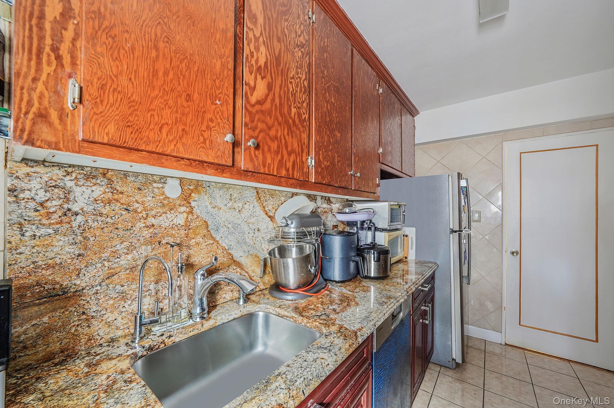 39-45 51st Street, Unit 5C Queens, NY 11377 - Photo 11 of 17 a kitchen with stainless steel appliances granite countertop a sink stove and refrigerator