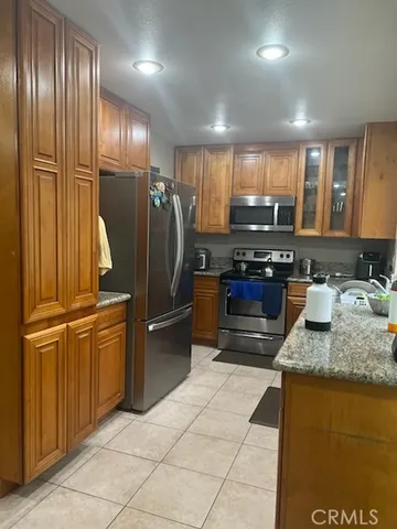 a kitchen with stainless steel appliances granite countertop a refrigerator and a sink