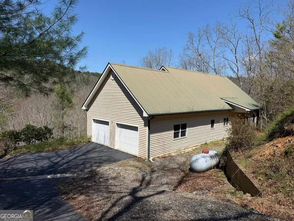 a view of a house with backyard and trees