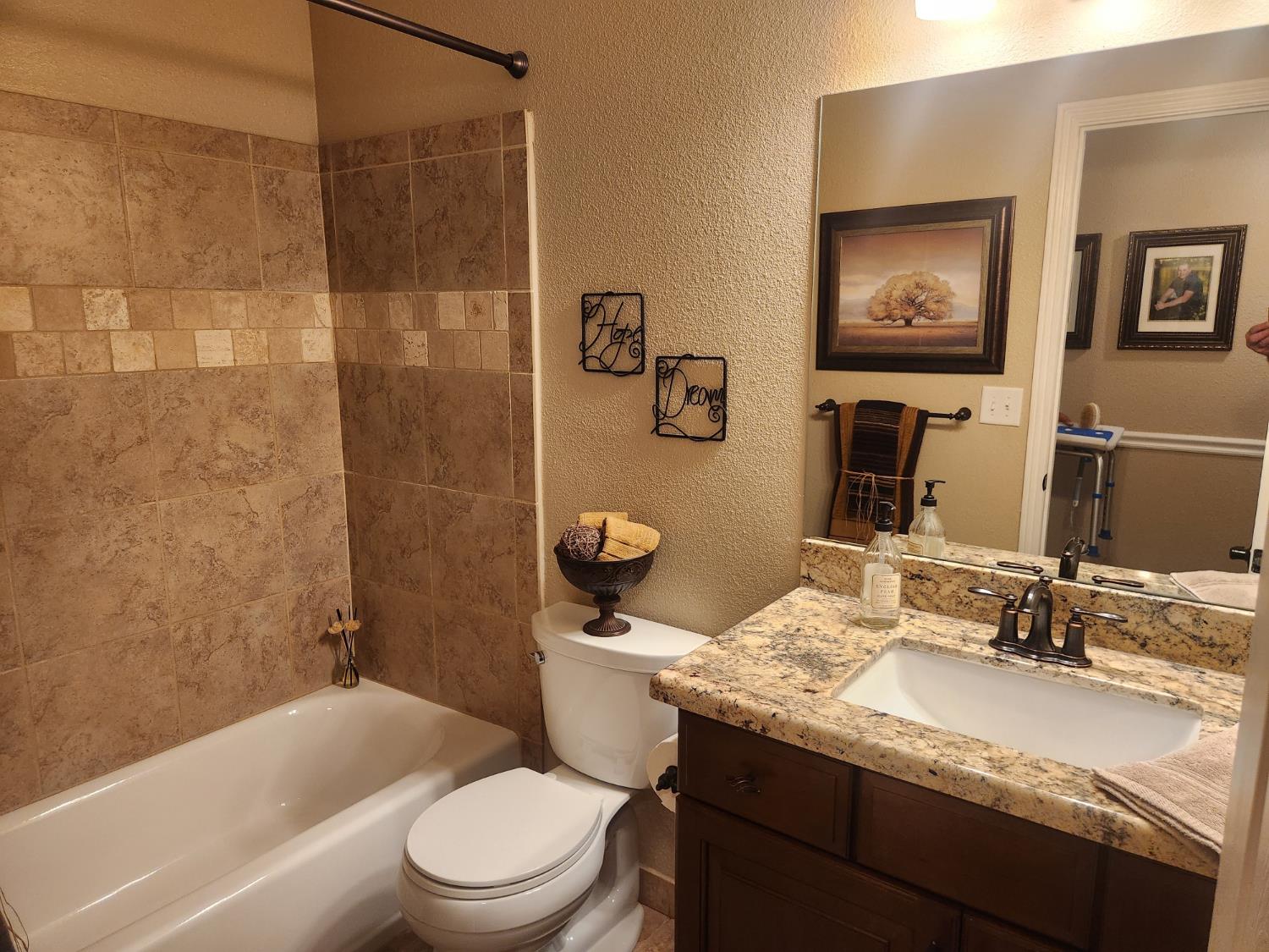 777 Jordanolo Drive Ripon, CA 95366 - Photo 23 of 61 a bathroom with a granite countertop toilet a sink and a mirror
