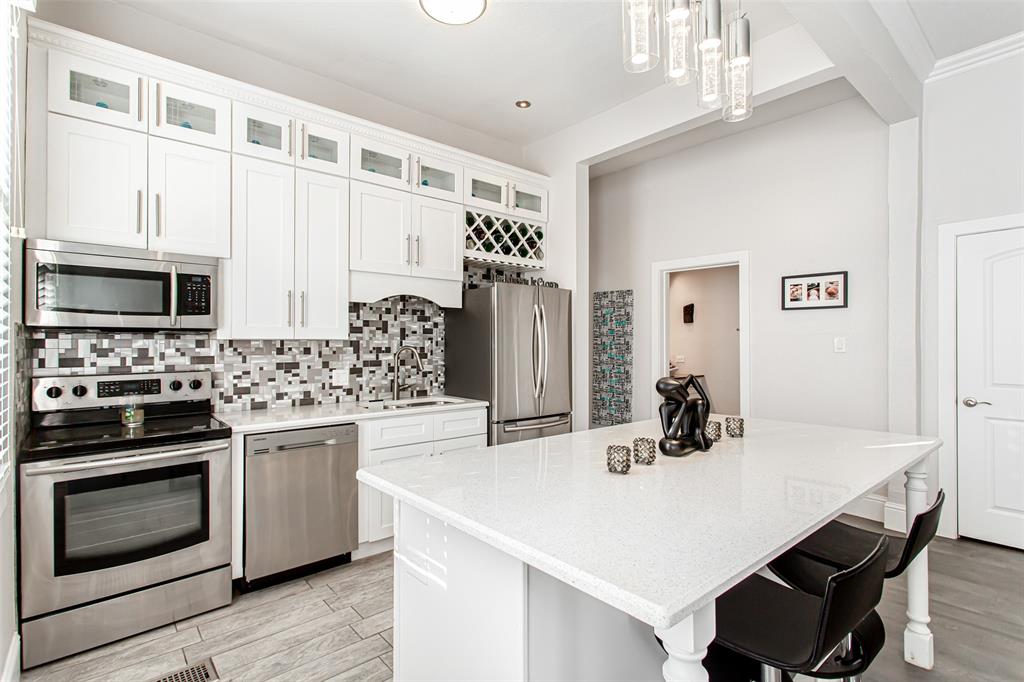 4719 Junius Street, Unit 1 Dallas, TX 75246 - Photo 19 of 40 a kitchen with a stove a sink and a refrigerator
