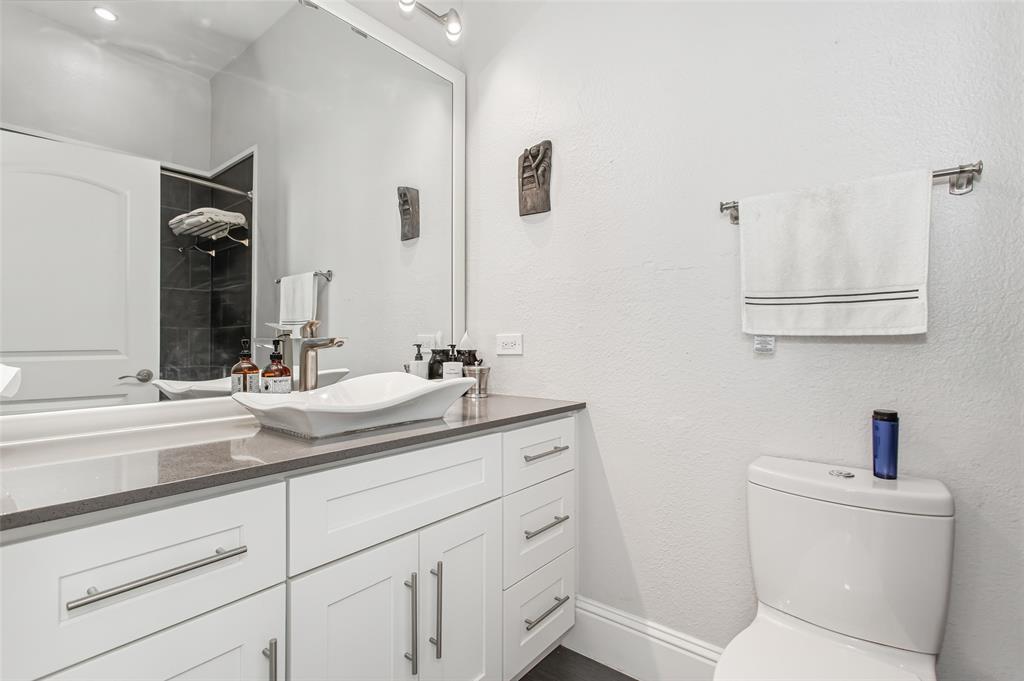 4719 Junius Street, Unit 1 Dallas, TX 75246 - Photo 22 of 40 a bathroom with a toilet sink and mirror