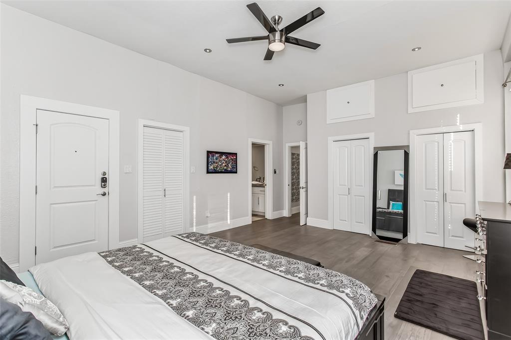 4719 Junius Street, Unit 1 Dallas, TX 75246 - Photo 27 of 40 a bedroom with a large bed and a chandelier