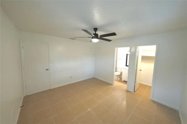 a view of an empty room and a ceiling fan