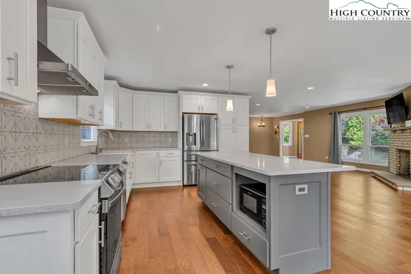 a kitchen with granite countertop a sink a counter top space stainless steel appliances and a window