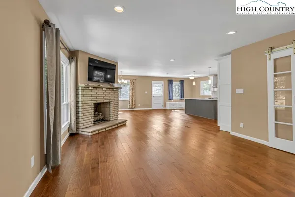 a view of a livingroom with wooden floor and a fireplace