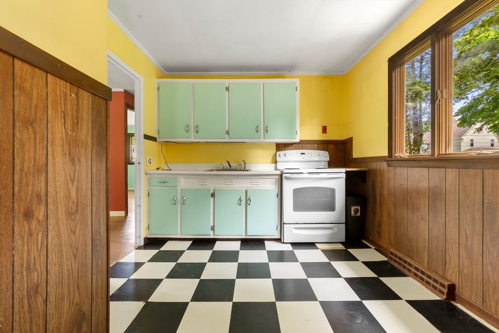 71 Union Street Hamilton, MA 01982 - Photo 7 of 21 a kitchen with a checkered floor and white cabinets