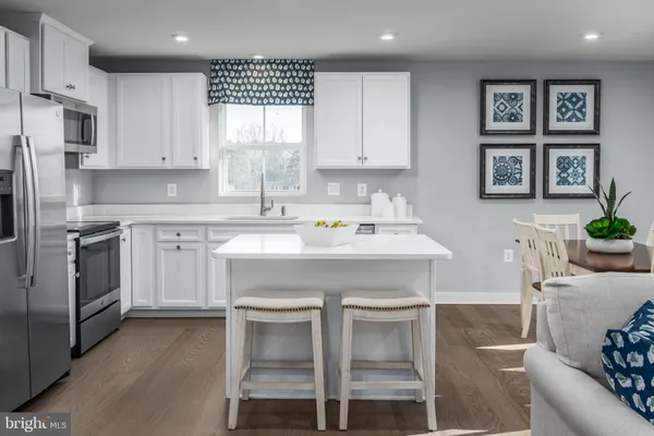 a kitchen with a stove a sink cabinets and a refrigerator