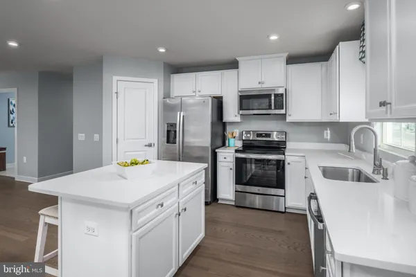 a kitchen that has a sink cabinets and stainless steel appliances