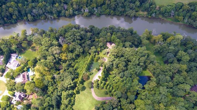 a view of a green field with wooden fence