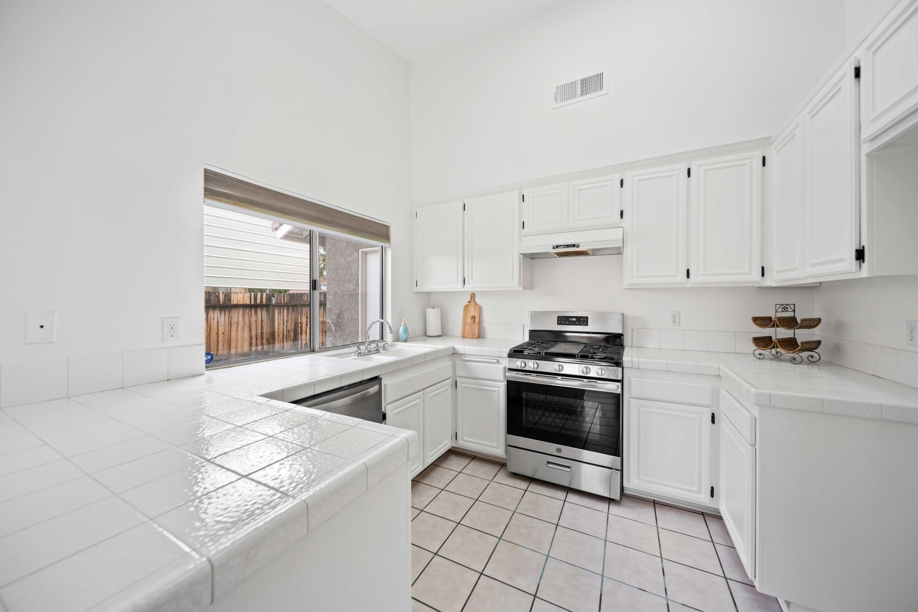 1247 Coventry Place Palmdale, CA 93551 - Photo 7 of 20 a kitchen with a stove a sink and a refrigerator
