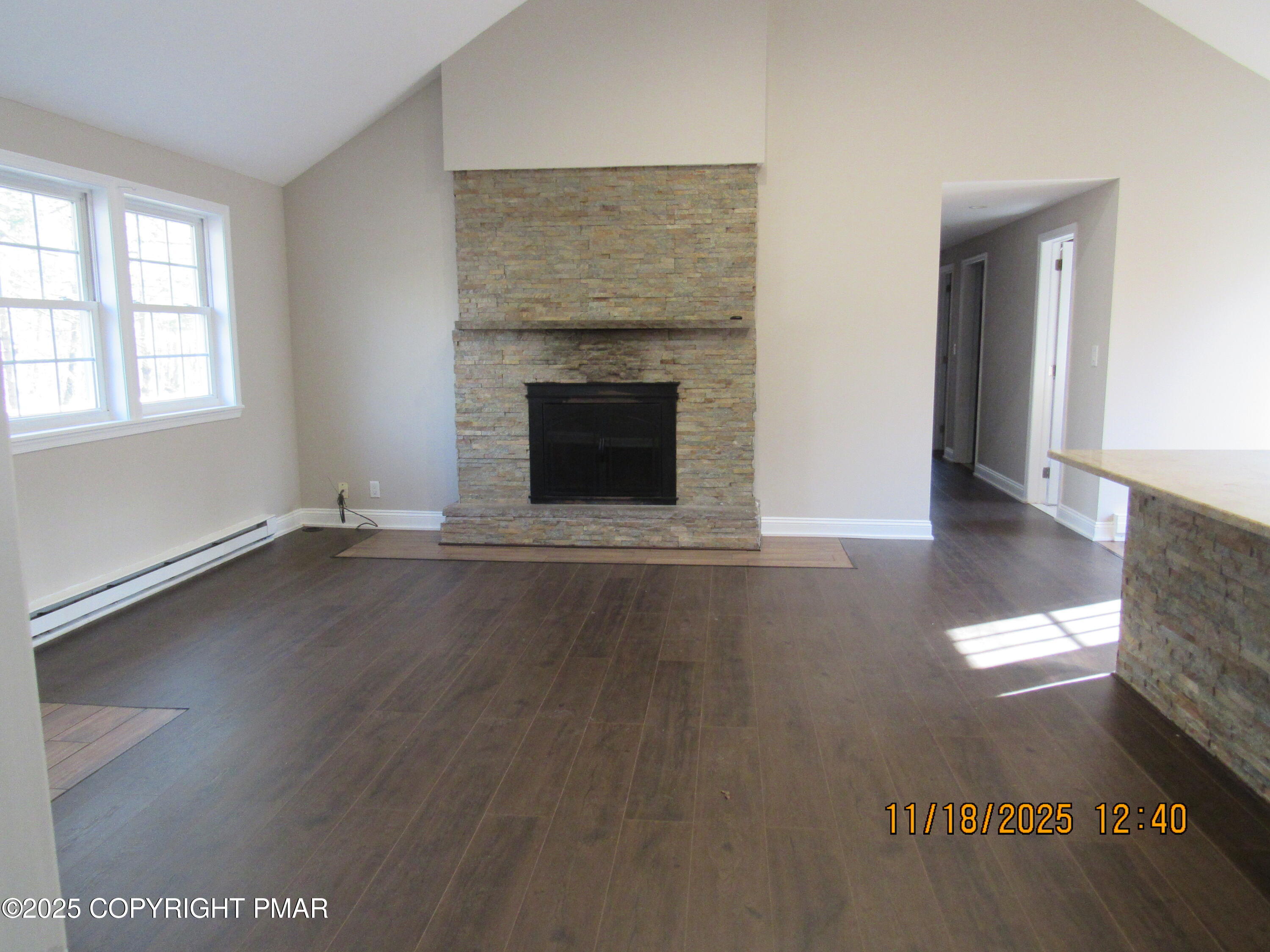 867 Underwood Road West East Stroudsburg, PA 18302 - Photo 11 of 36 an empty room with wooden floor fireplace and windows