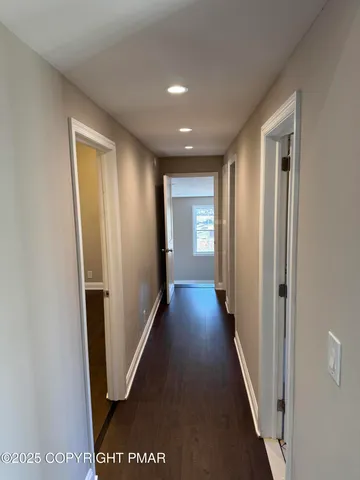 a view of a hallway with wooden floor and staircase