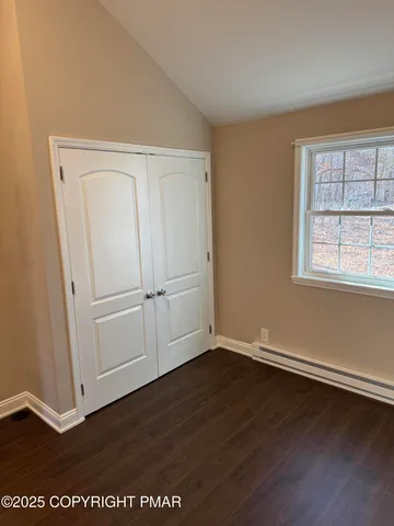 an empty room with wooden floor and window