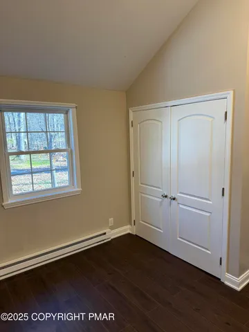 an empty room with wooden floor and window