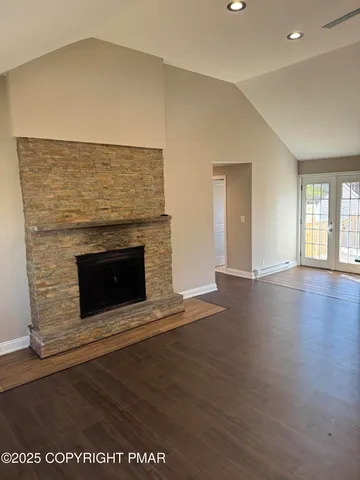 an empty room with wooden floor and fireplace