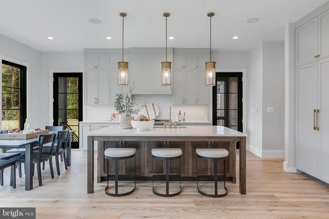 a kitchen with stainless steel appliances a stove a sink a refrigerator and a wooden cabinets