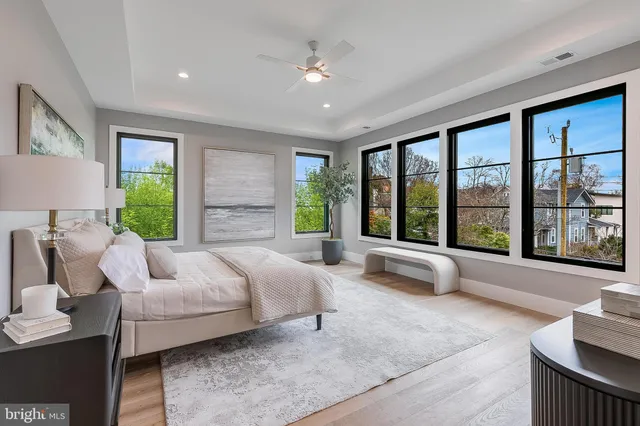 a view of an empty room with wooden floor and windows