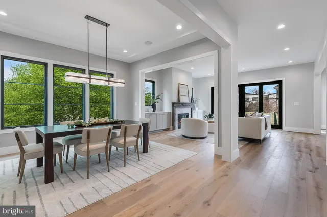 a dining room with wooden floor a chandelier a wooden table and chairs