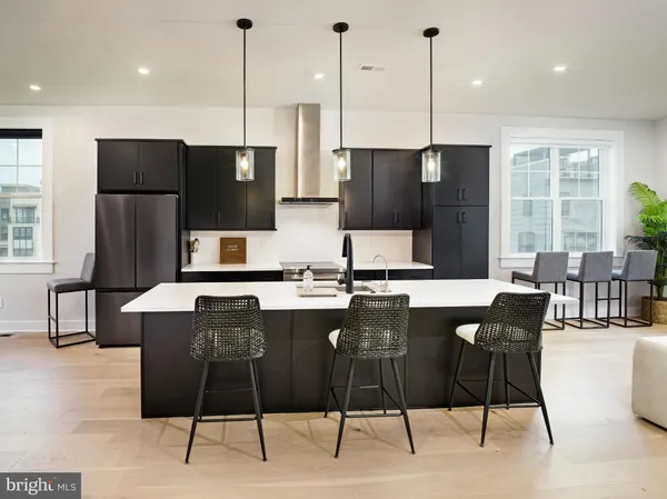 a kitchen with stainless steel appliances granite countertop a refrigerator a stove a sink a dining table and chairs