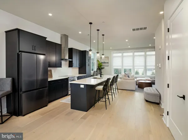 a kitchen with stainless steel appliances kitchen island granite countertop a refrigerator a sink a stove and a oven