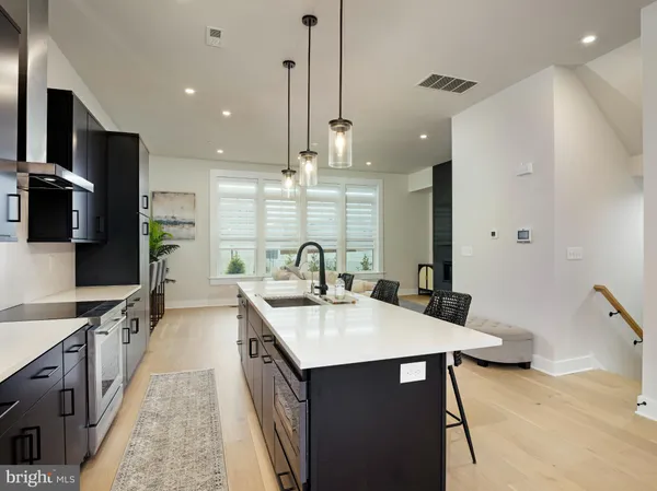 a kitchen with kitchen island a sink stove and wooden floor