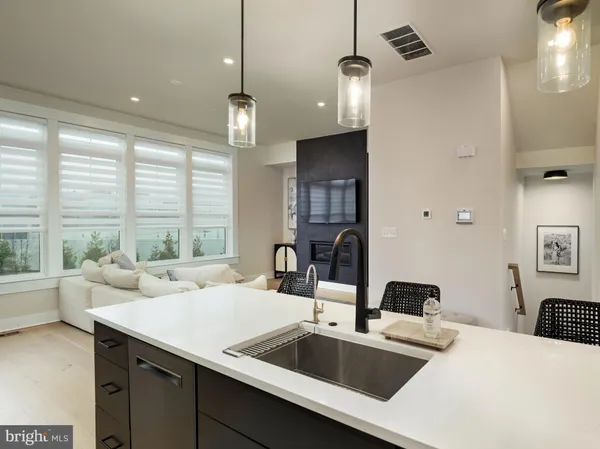 a kitchen with a sink a counter and chairs