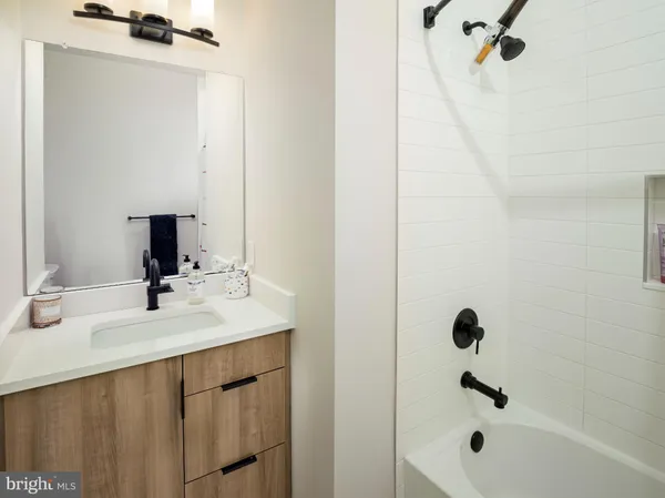 a bathroom with a sink vanity and shower
