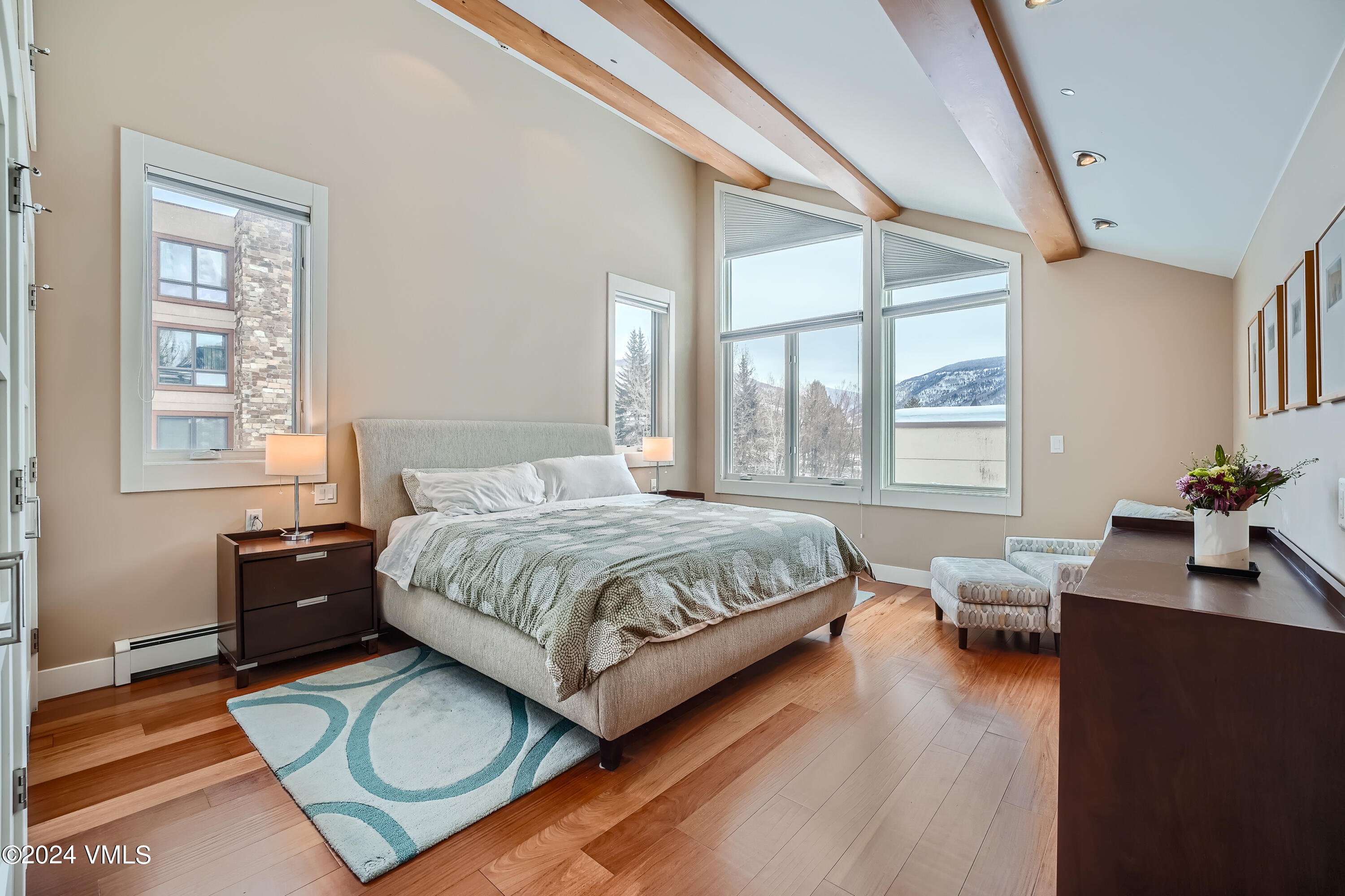 963 Lions Ridge Loop, Unit 535 Vail, CO 81657 - Photo 11 of 26 a spacious bedroom with a bed and wooden floor