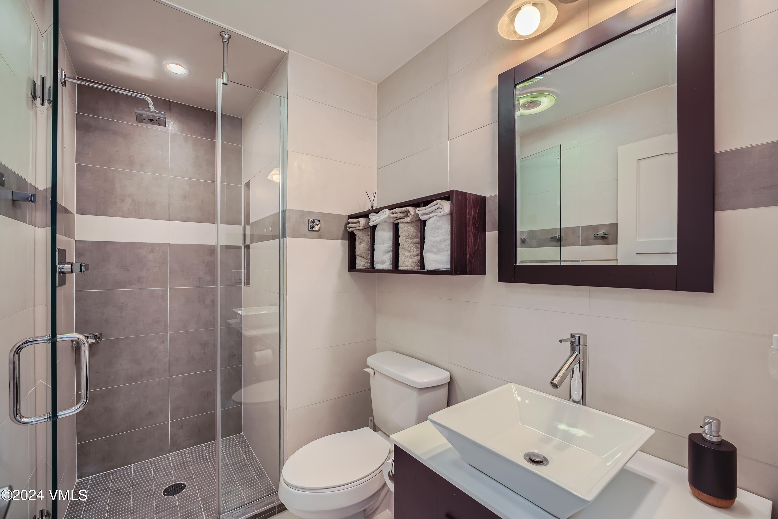 963 Lions Ridge Loop, Unit 535 Vail, CO 81657 - Photo 18 of 26 a bathroom with a toilet a sink a mirror and shower